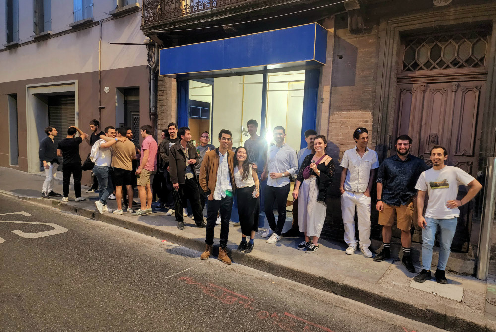 L'équipe et des amis célébrant l'ouverture devant le nouveau bureau
